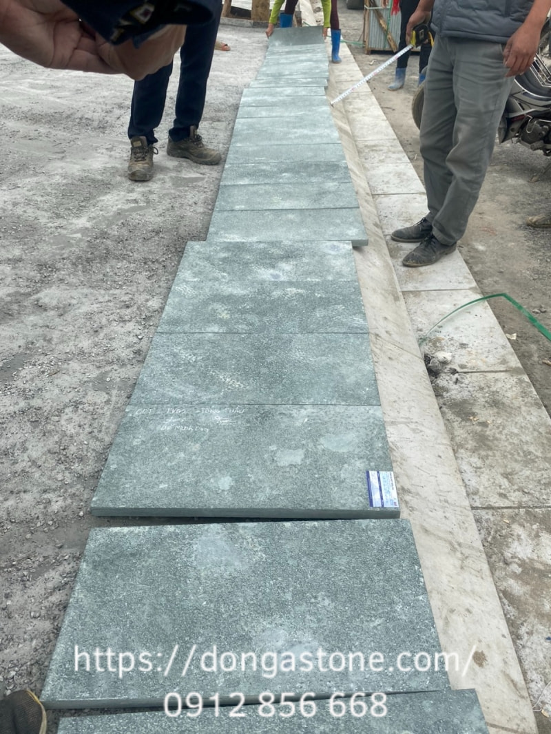 Đặt từng viên đá xanh Thanh Hóa lên lớp vữa, căn chỉnh cao độ và mạch đều nhau để bề mặt phẳng đẹp, chắc chắn và đúng kỹ thuật.